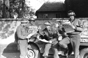 Żołnierze US Army MP czytają o niemieckiej kapitulacji w gazecie "Stars and Stripes" fot. U.S. Army