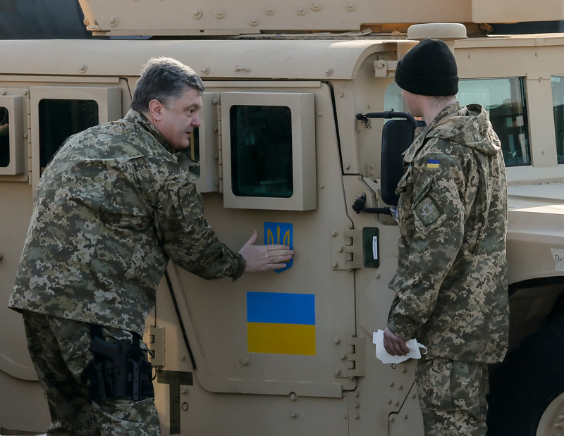 Petro Poroszenko przykleja symbol ukraińskiej flagi na drzwiach jednego z Humvee fot.Sergey Dolzhenko/EPA