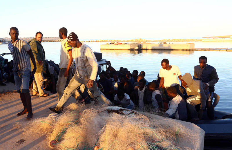 Nielegalni imigranci z Afryki u wybrzeży miasta Guarabouli, 60 kilometrów od Trypolisu, w Libii fot.STR/EPA