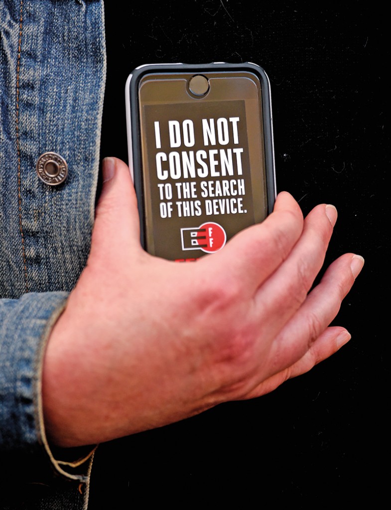 “Nie zgadzam się na przeszukiwanie tego urządzenia” - mówi napis na  wyświetlaczu telefonu jednego z uczestników demonstracji przed sklepem Apple w San Francisco fot.John B. Mabanglo/EPA