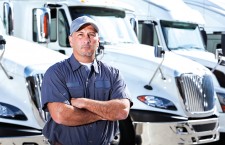 Truck driver standing in front of big rigs
